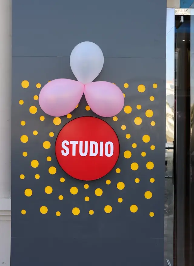 Red STUDIO sign with pink balloons at the Ashley Fotografia entrance