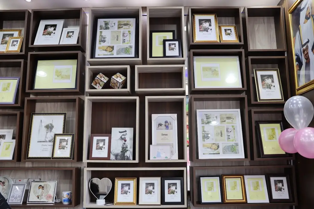 Shelves of framed sample prints and photo cubes at Ashley Fotografia